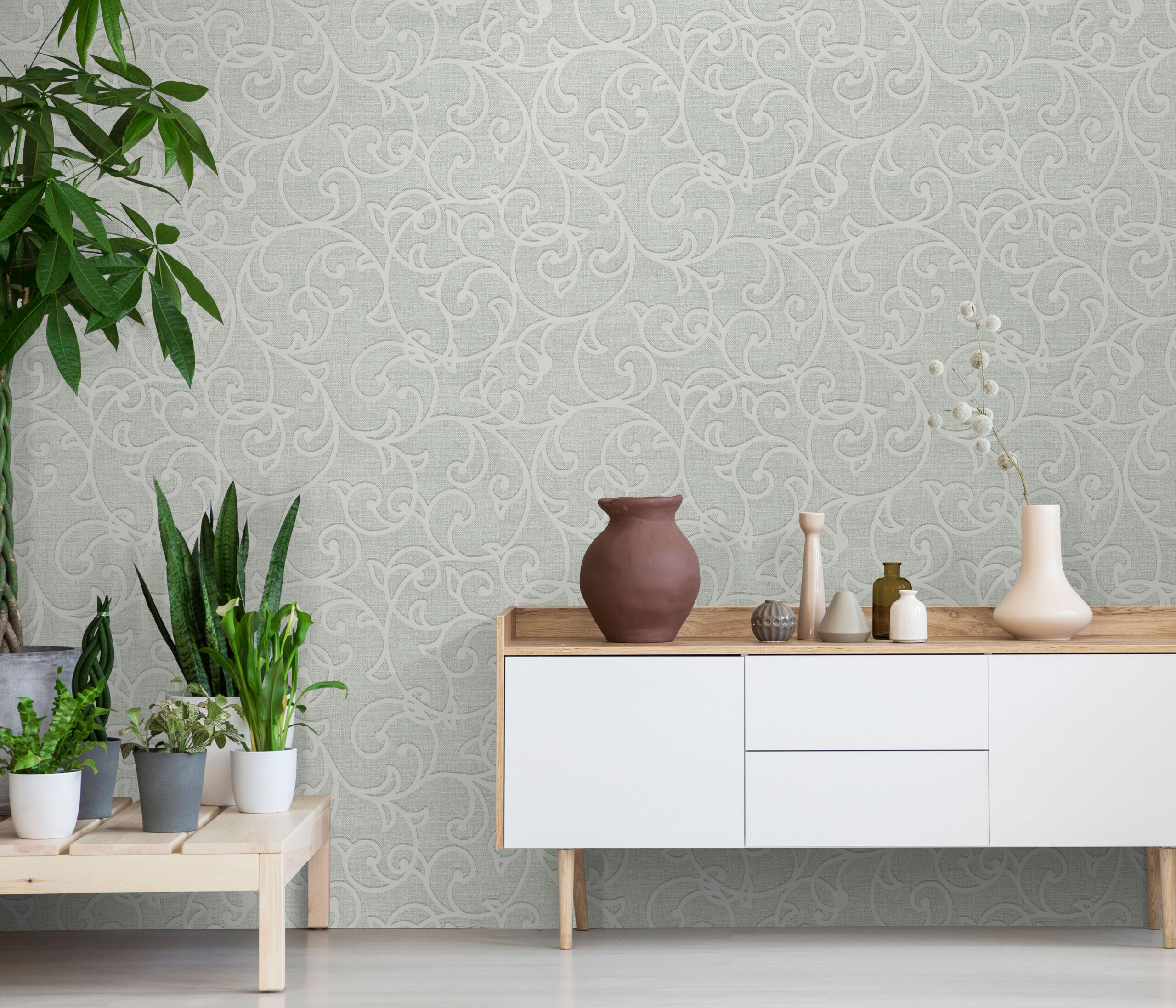 Real photo of a botanic living room interior with burlap artwork on the gray wall and white cupboard surrounded by plants